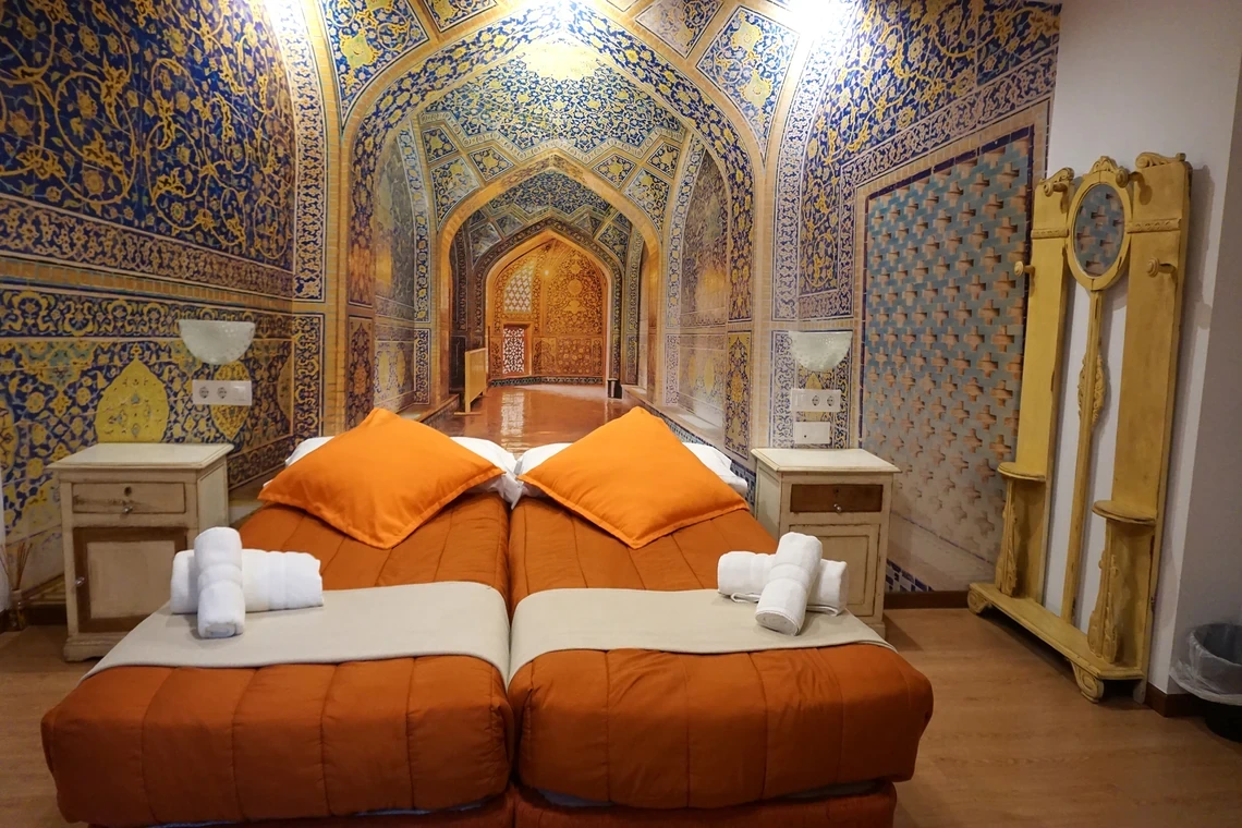 Dormitorio con mural de inspiración oriental, camas gemelas y mesitas de noche Casual Alquimia Cádiz.