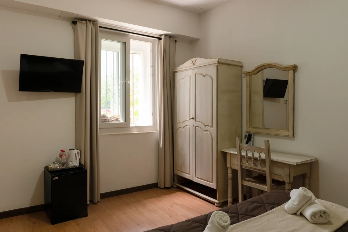 Habitación de hotel con Casual Alquimia Cádiz, armario, escritorio y espejo.