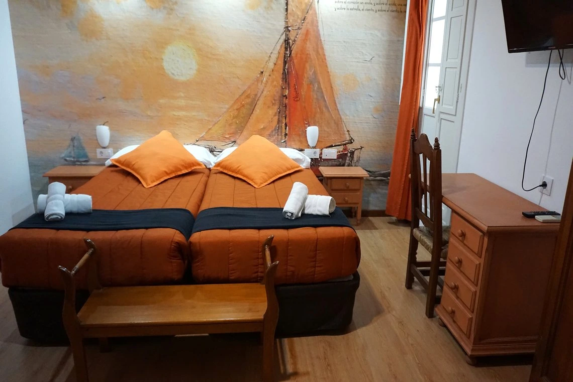 Habitación con dos camas, escritorio y mural náutico - ideal para tu Casual Alquimia Cádiz.