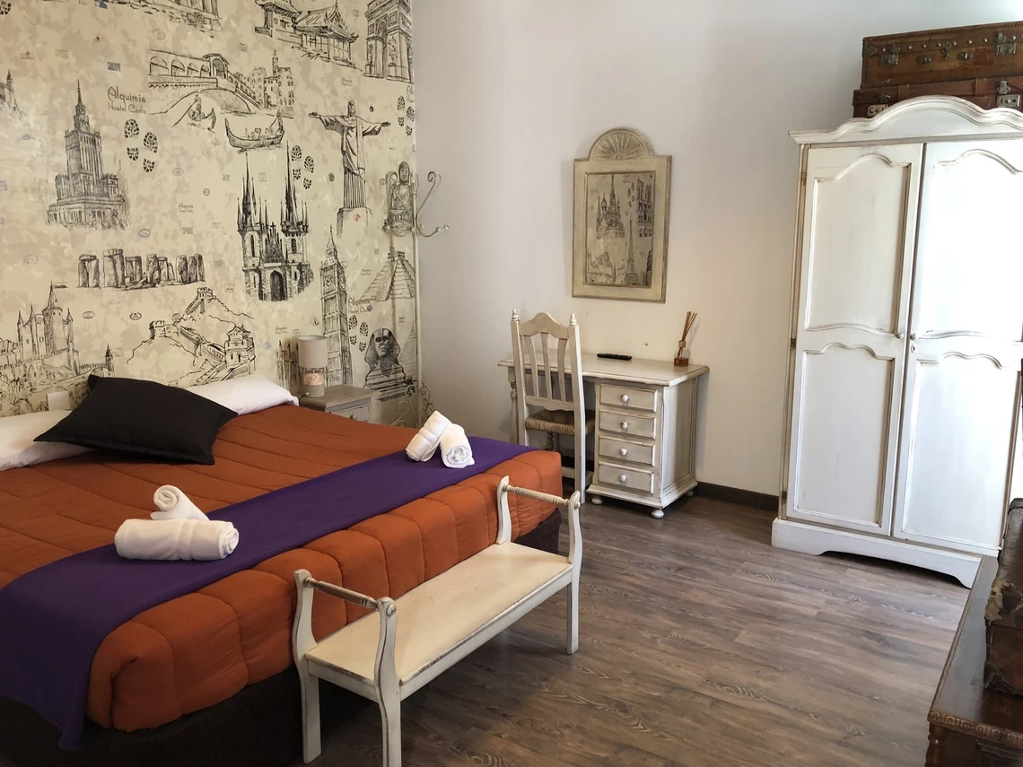 Habitación temática de viajes con cama, escritorio y armario. Casual Alquimia Cádiz