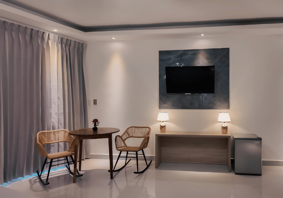 Chambre d'hôtel avec table, chaises, TV et mini-réfrigérateur. Idéal pour un séjour confortable Casual: On The Beach Bayahibe.