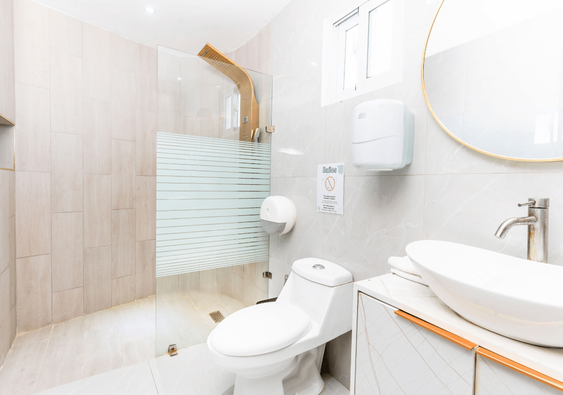 Baño moderno con ducha, inodoro y lavabo. Ideal para Casual: On The Beach Bayahibe.