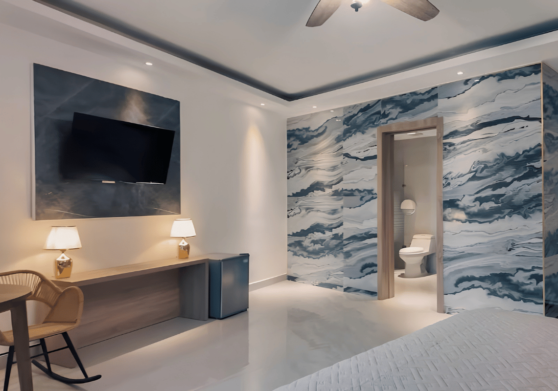 Chambre moderne avec mur marbré, TV, mini-bar et salle de bain attenante. Idéal pour un séjour Casual: On The Beach Bayahibe.