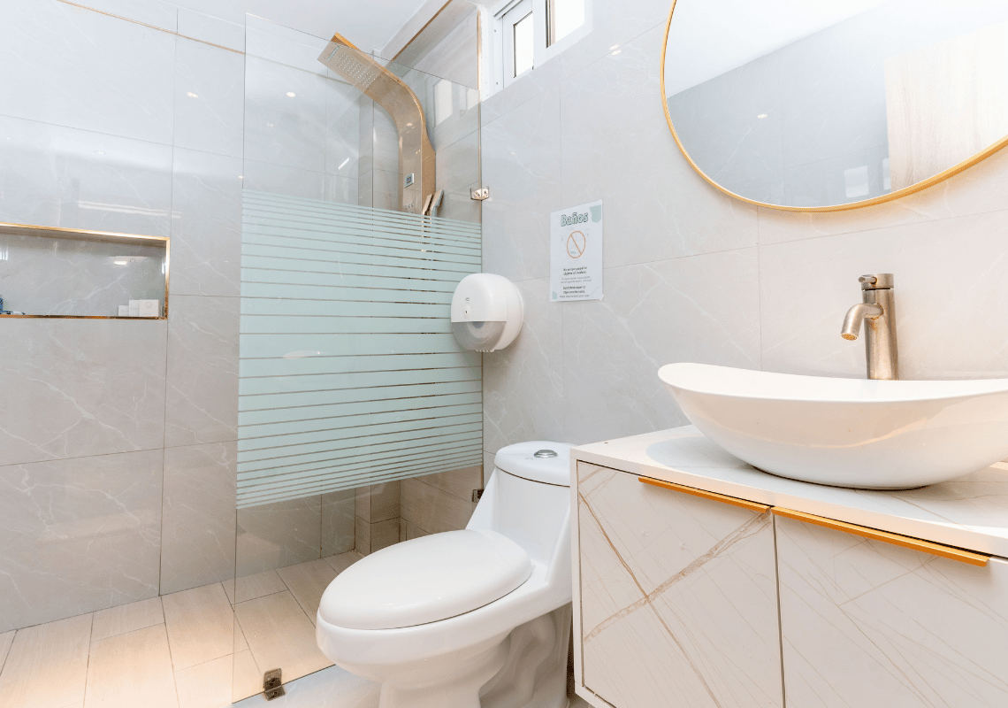 Baño moderno con ducha, inodoro y lavabo en hotel. Casual: On The Beach Bayahibe