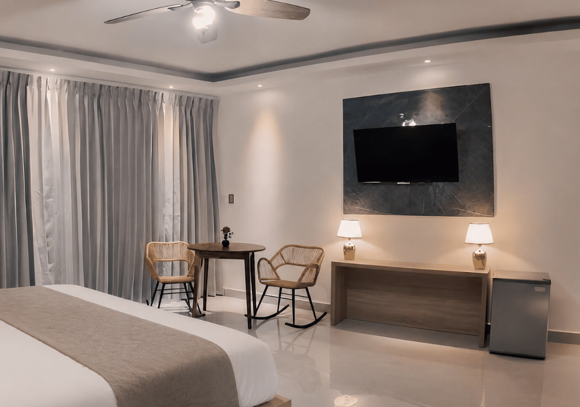 Chambre d'hôtel moderne avec lit, coin repas, TV et mini-bar. Parfait pour votre Casual: On The Beach Bayahibe.