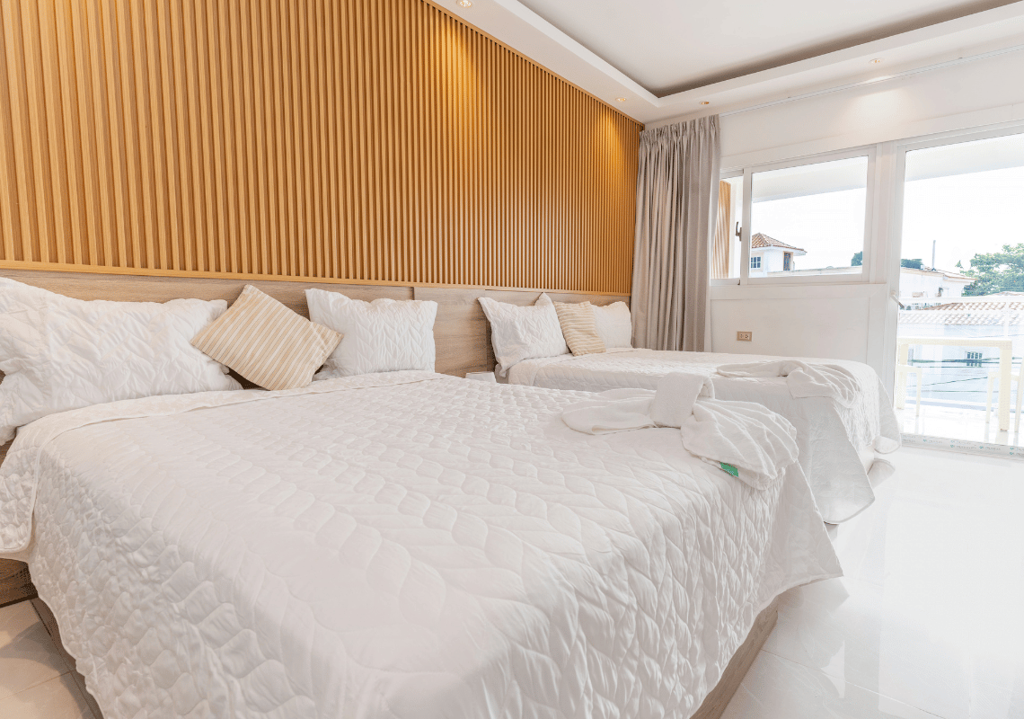 Habitación doble con @Casual: On The Beach Bayahibe, ropa de cama blanca y diseño de madera.