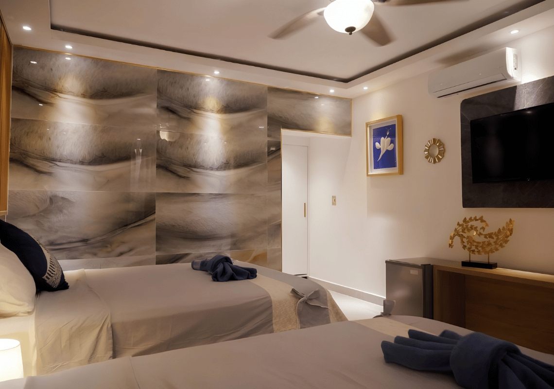 Chambre double confortable avec deux lits, décor moderne, mur carrelé et climatisation. Idéal pour votre séjour Casual: On The Beach Bayahibe.