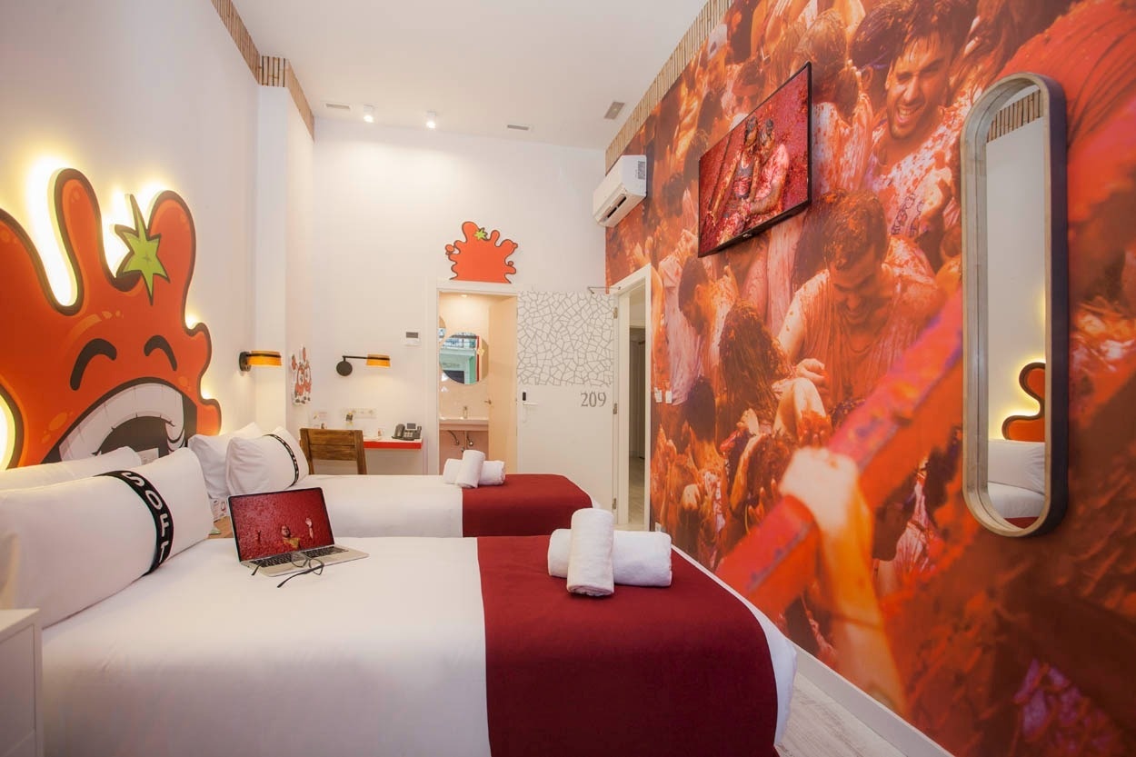 Habitación temática para dos en Casual Socarrat Valencia, con mural vibrante y camas cómodas.
