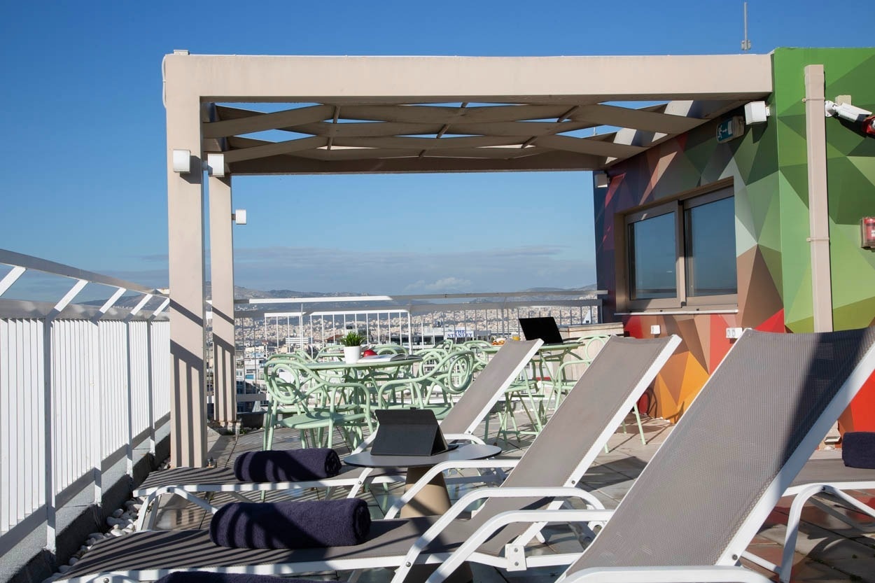 Sonnendeck mit Liegestühlen, Tischen & Blick über Athen. Casual Kubic Athens.