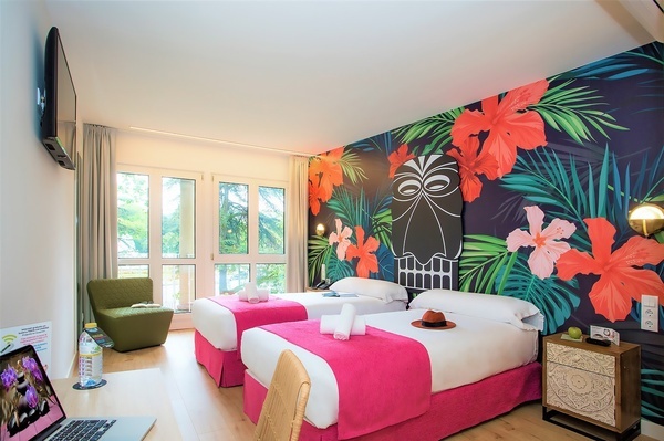 um quarto de hotel com duas camas e um laptop