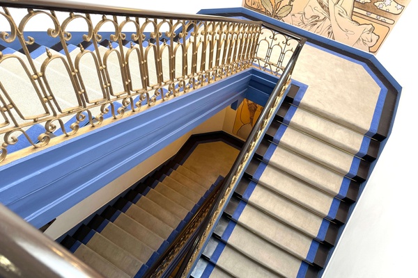 a blue and white staircase with a gold railing