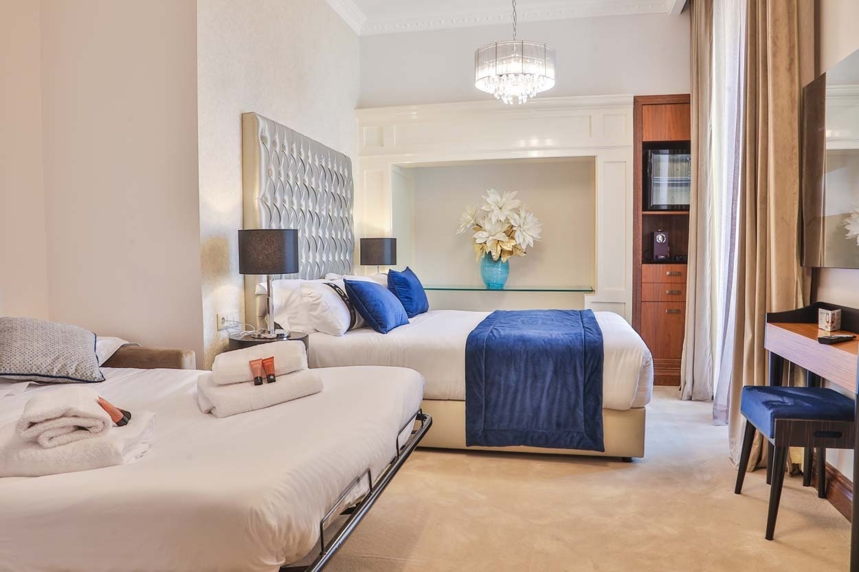 Gemütliches Zimmer im Casual Belle Époque - Boutique-Hotel im Zentrum von Lissabon, mit zwei Betten und einer Schlafcouch.