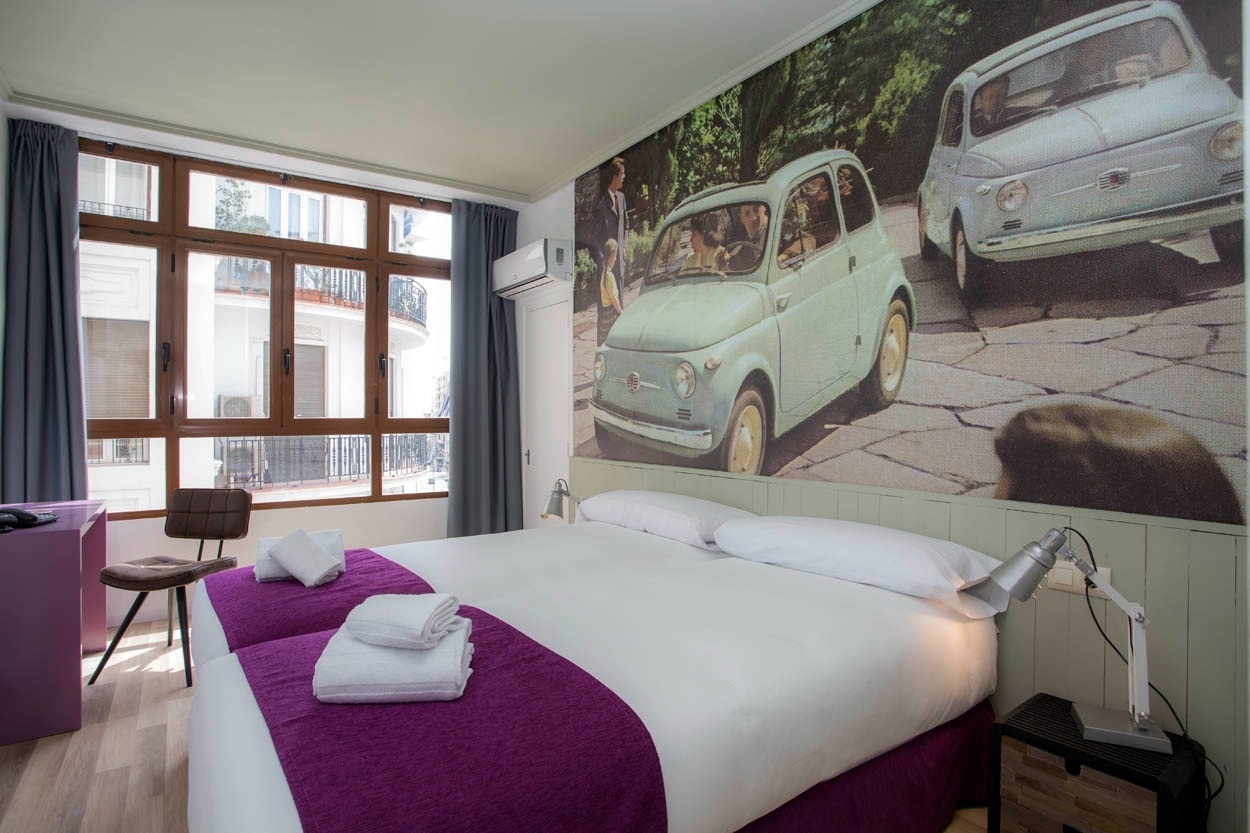 Habitación temática con mural de coches vintage en Casual Vintage Valencia.