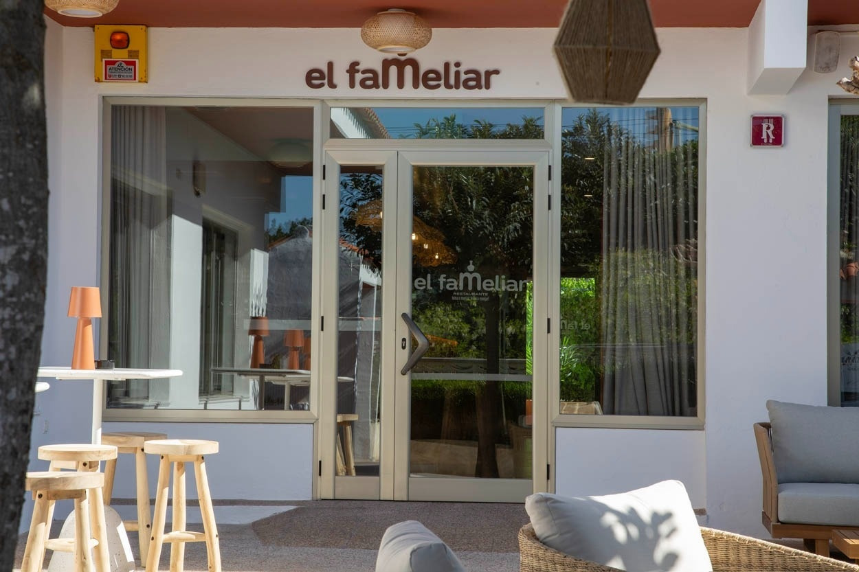 Façade du Casual Bahía Ibiza – Hôtel décontracté près de la plage, avec logo et tables extérieures.