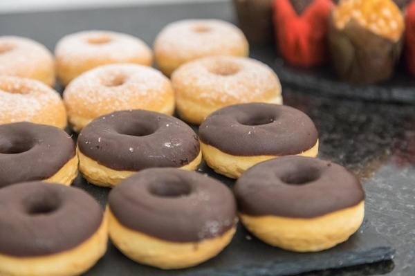 a variety of donuts are on a table including chocolate and powdered sugar