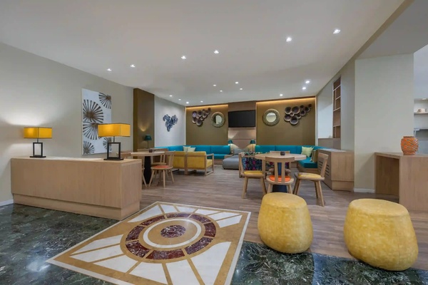 een woonkamer met tafels en stoelen en een mozaïekvloer
