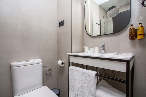 un baño con inodoro , lavabo y espejo