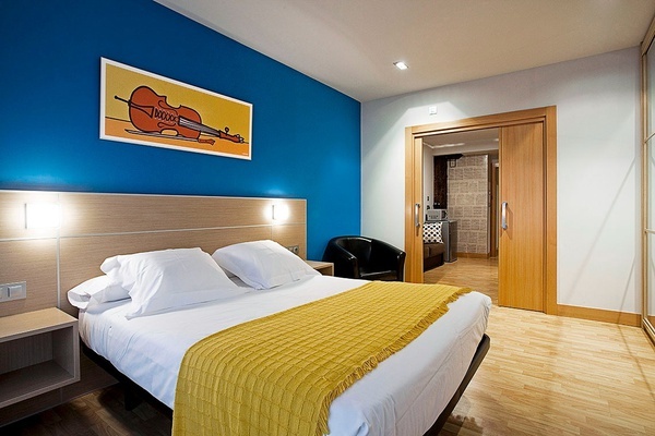 a bedroom with a violin on the wall above the bed