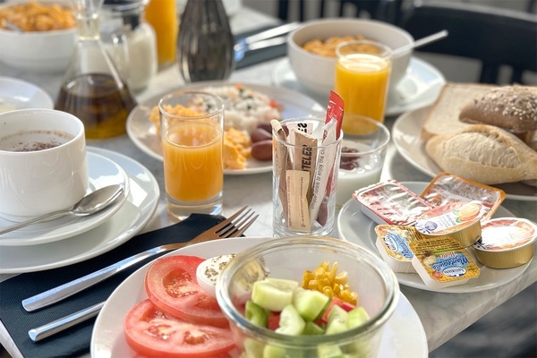 une table de petit-déjeuner avec des assiettes de nourriture et des boîtes de beurre