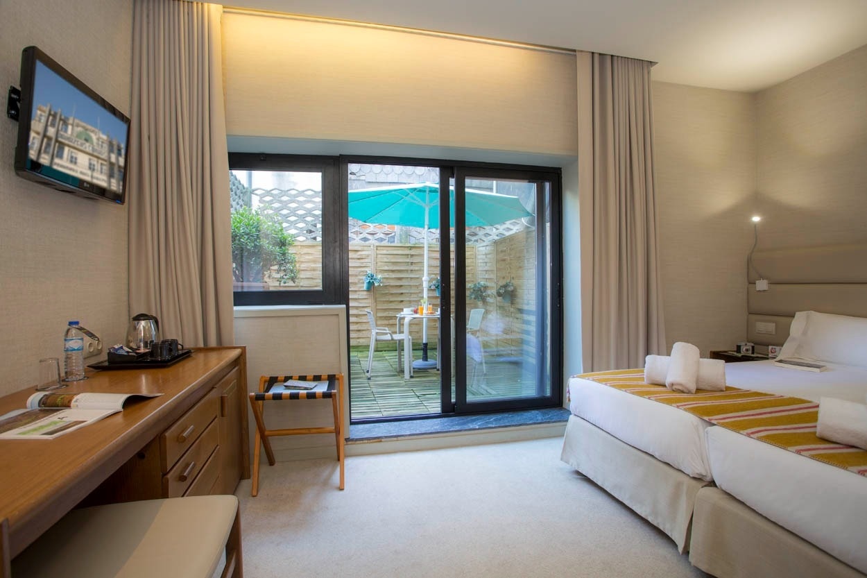 Gemütliches Zimmer mit Terrasse im Casual Inca Porto - Zentrales Hotel in Porto. Moderne Ausstattung und Blick ins Grüne.
