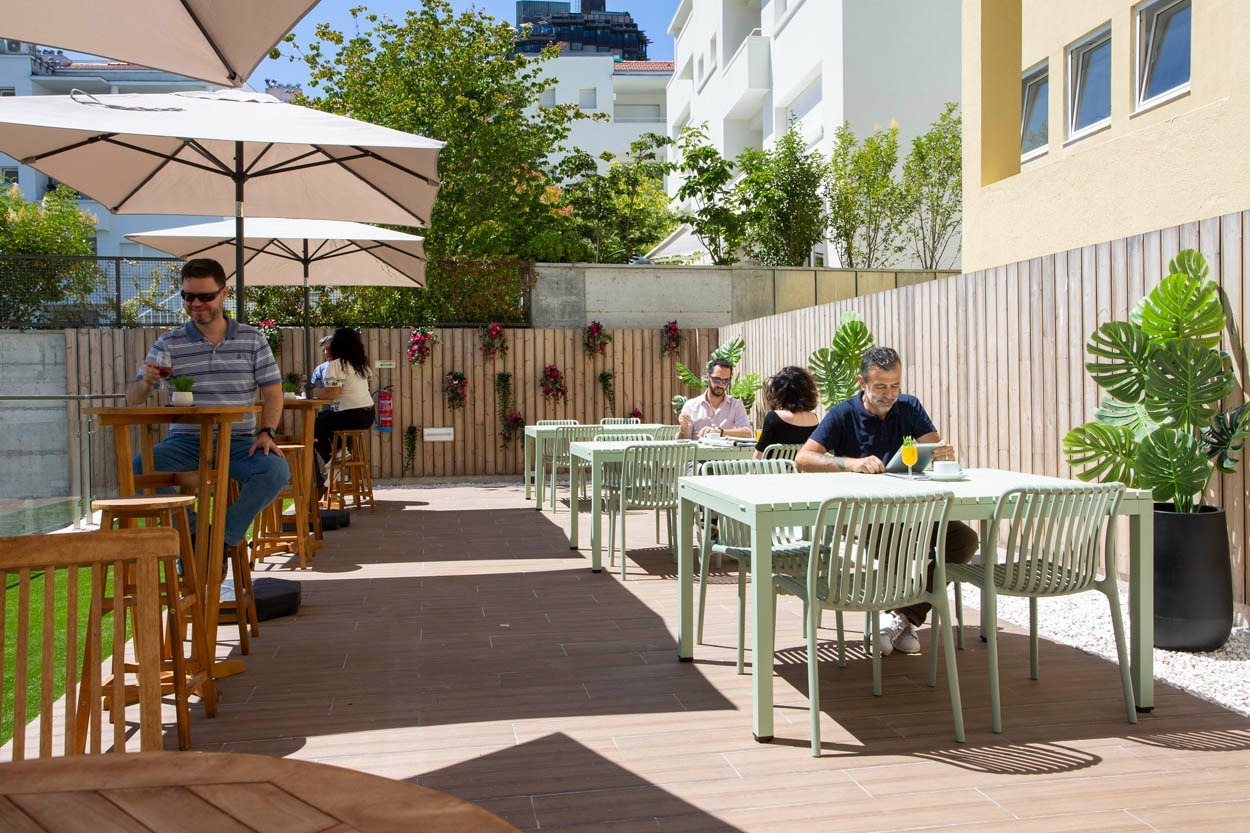Terrazza esterna Casual Raízes Porto - Boutique Hotel, perfetta per un pasto rilassato.