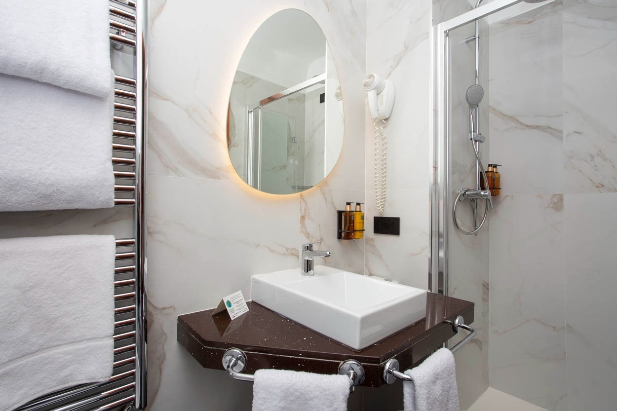 Modernes Badezimmer im Casual Eclettico Milano Hotel mit Dusche, Waschbecken und Handtuchhalter, Nähe Bahnhof Centrale