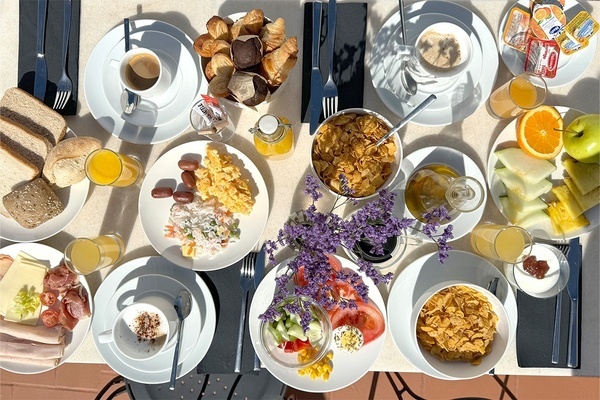 une table remplie de plats de nourriture y compris un bol de céréales