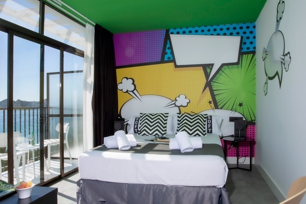 una habitación con una cama y una pared con un dibujo de cómic