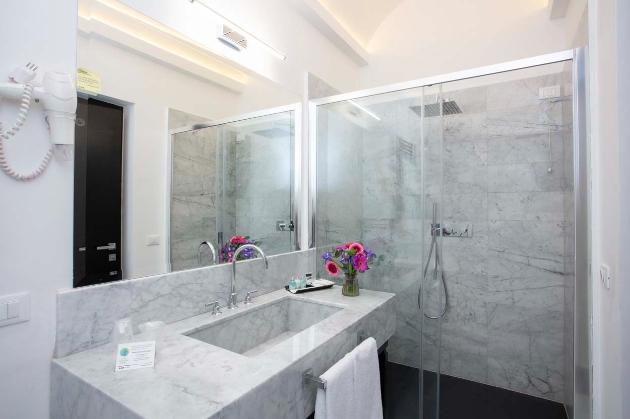 Modernes Marmorbad mit Dusche und Doppelwaschbecken im Casual Rinascimento Firenze, zentral gelegen. Ideal für Ihren Aufenthalt in Florenz.