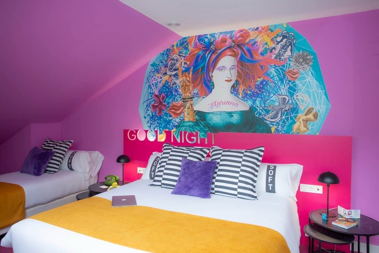 Habitación vibrante con mural llamativo en Casual Ilbira Granada, hotel boutique con encanto.