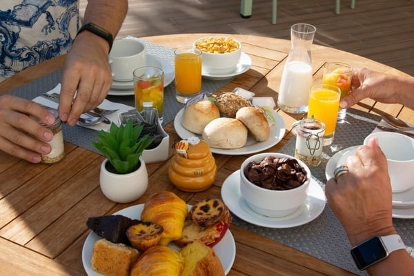 two people are sitting at a table with plates of food and drinks