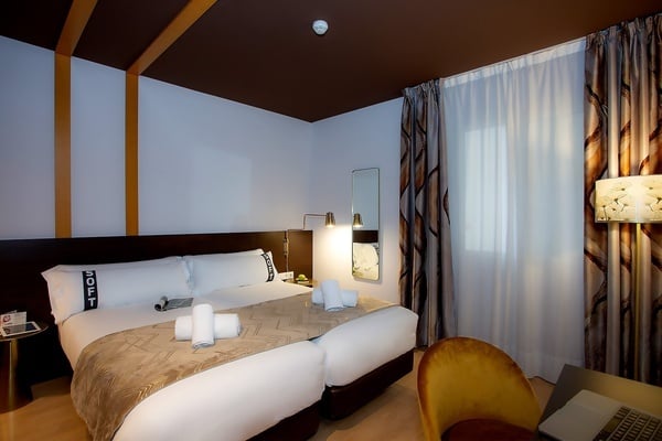 une chambre d' hôtel avec un lit double et une chaise jaune