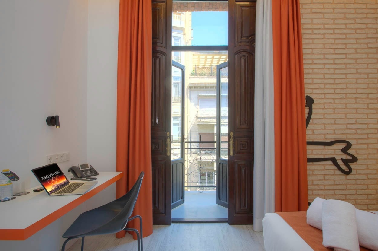 Habitación con balcón, escritorio y vista exterior, Casual Socarrat Valencia.