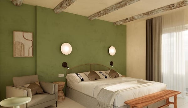 une chambre avec un lit et une chaise et un mur vert