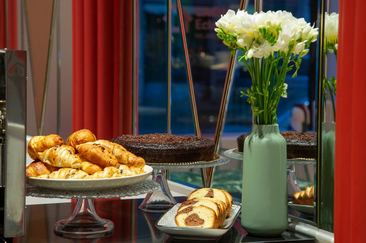 Buffet mit süßen Leckereien und Blumenstrauß im Casual Eclettico Milano - Hotel nähe Bahnhof Centrale.