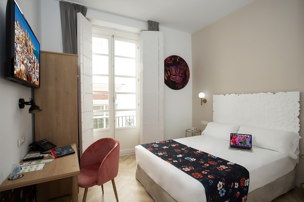 a hotel room with a laptop on the bed