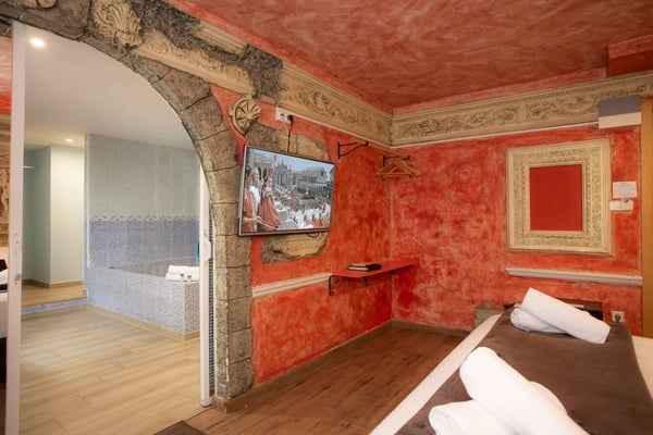 una habitación con paredes rojas y una televisión encima