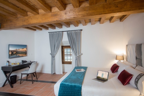 a hotel room with a laptop on the bed