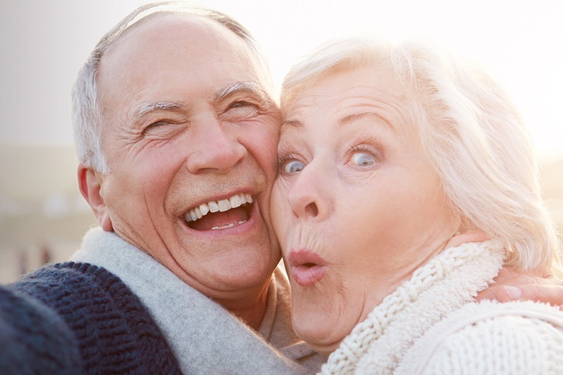 een man en een vrouw lachen en een vrouw maakt een grappig gezicht