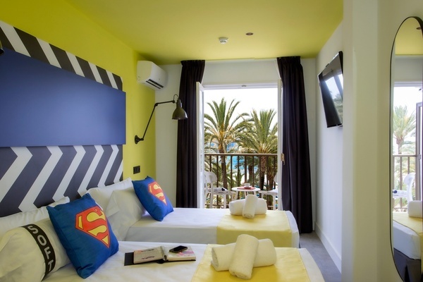 una habitación con dos camas y una almohada de superman