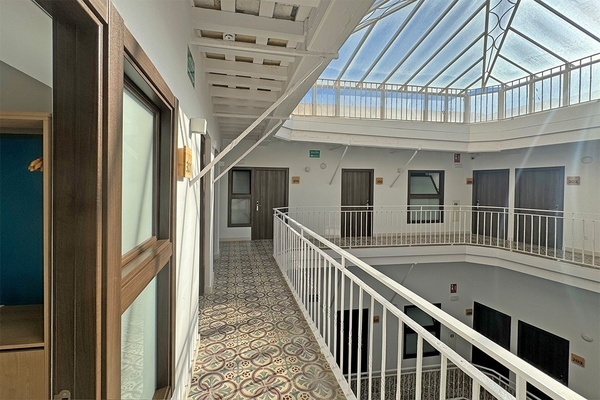 a hallway with a glass roof and a sign that says ' emergencia ' on it