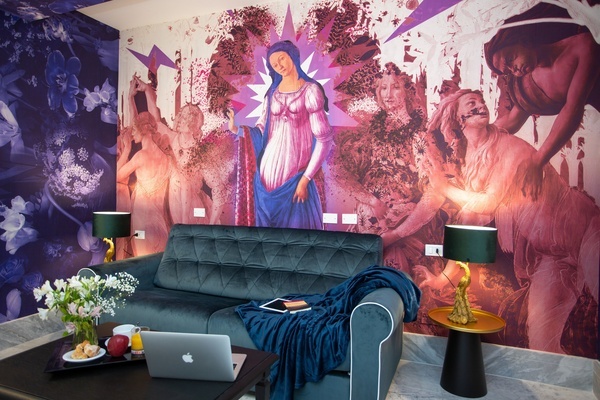 a living room with a painting of a woman on the wall