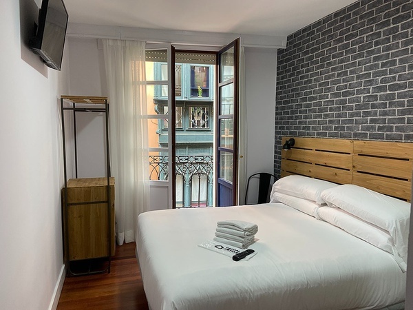a hotel room with a brick wall and a bed
