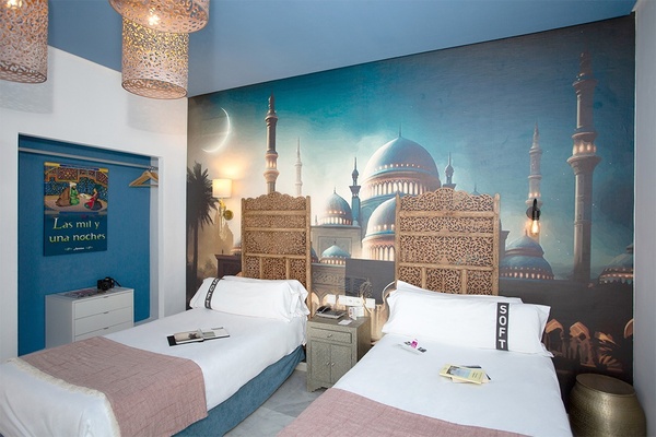 une chambre d' hôtel avec deux lits et une peinture murale sur le mur