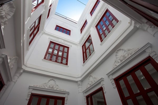 un edificio blanco con muchas ventanas rojas