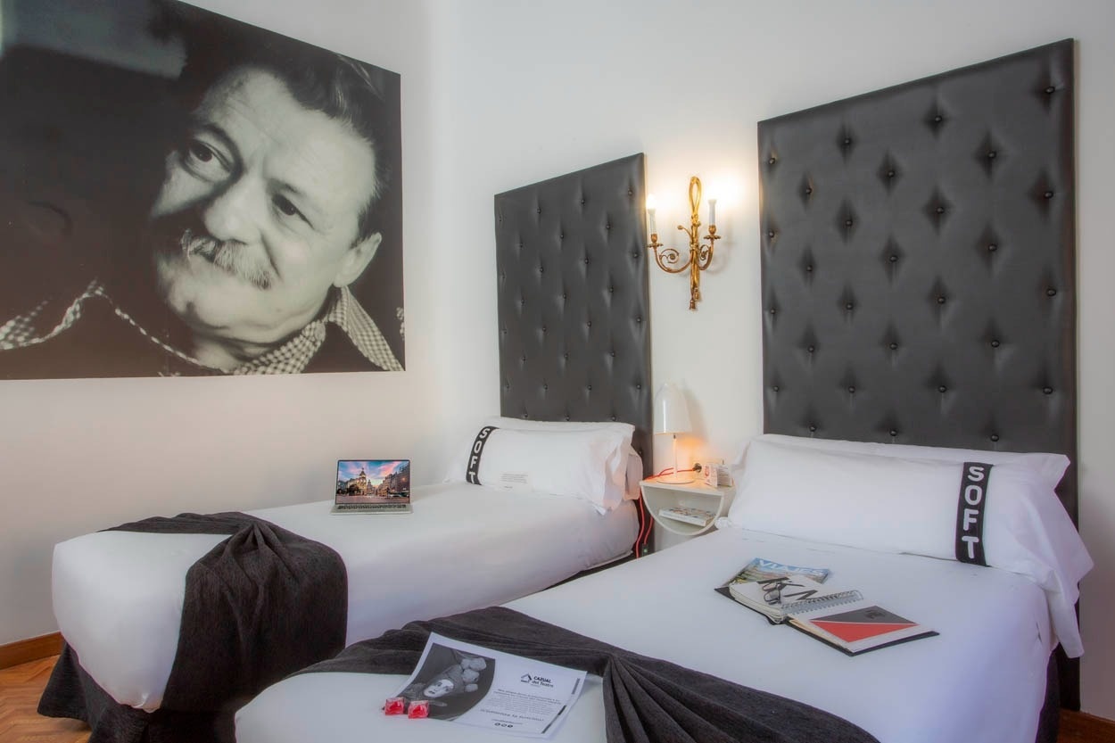 Zwei Betten im Casual del Teatro Madrid, Boutique-Hotel nahe Gran Vía mit Porträt an der Wand.