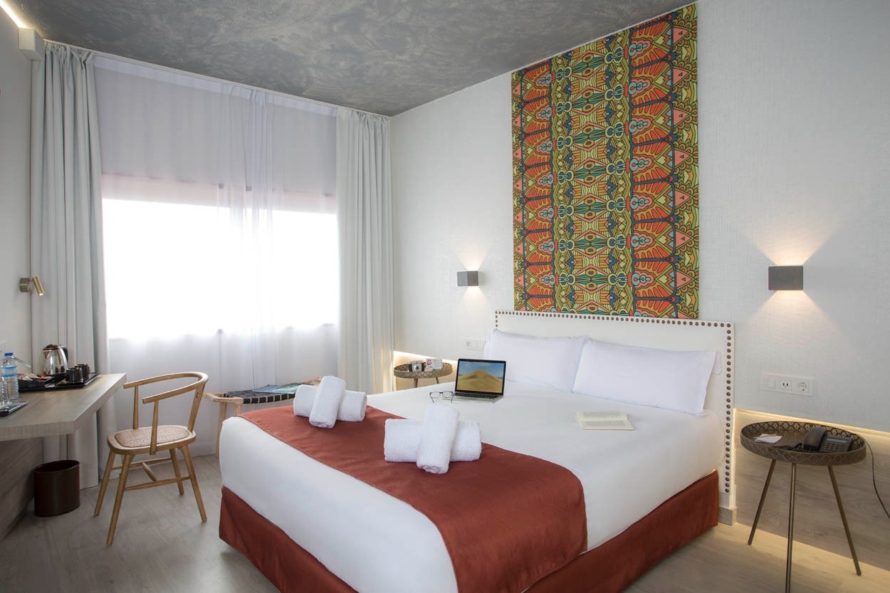 Entspannendes Zimmer im Casual Inca Porto: Zentrales Hotel mit bunter Wandkunst, bequemem Bett & modernem Schreibtisch.