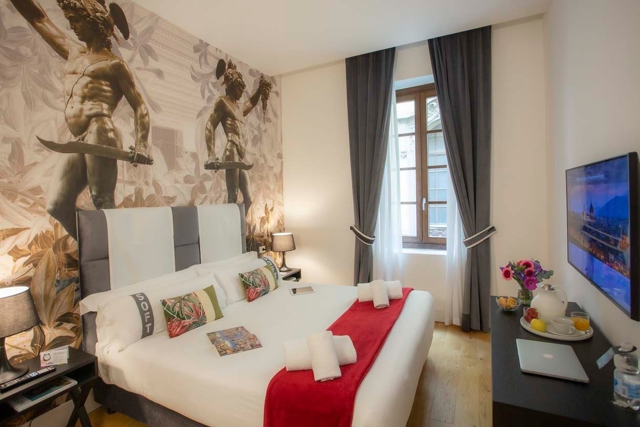Stilvolles Hotelzimmer im Casual Rinascimento Firenze mit Wandgemälden und luxuriösem Interieur. Zentral gelegen.