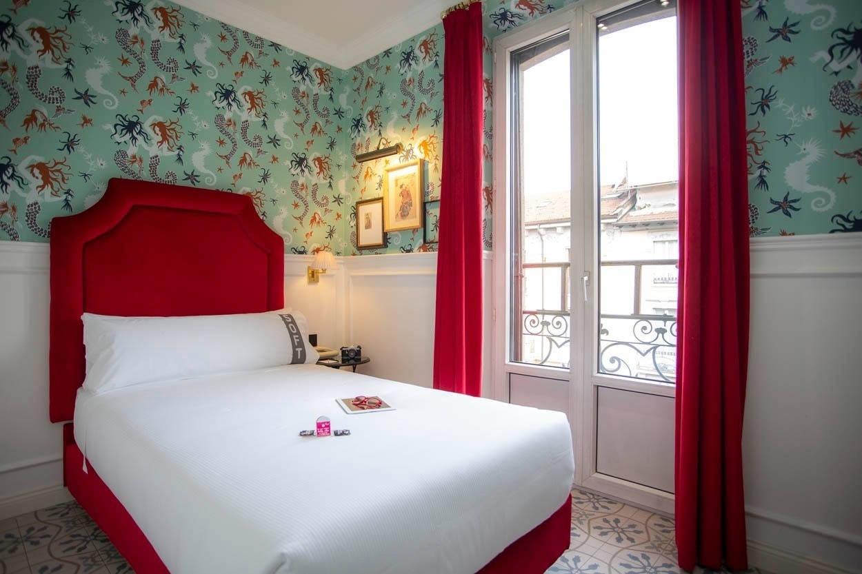 Einzigartiges Zimmer im Casual Eclettico Milano – Hotel Mailand mit Meeresmotiv-Tapete und roten Akzenten.