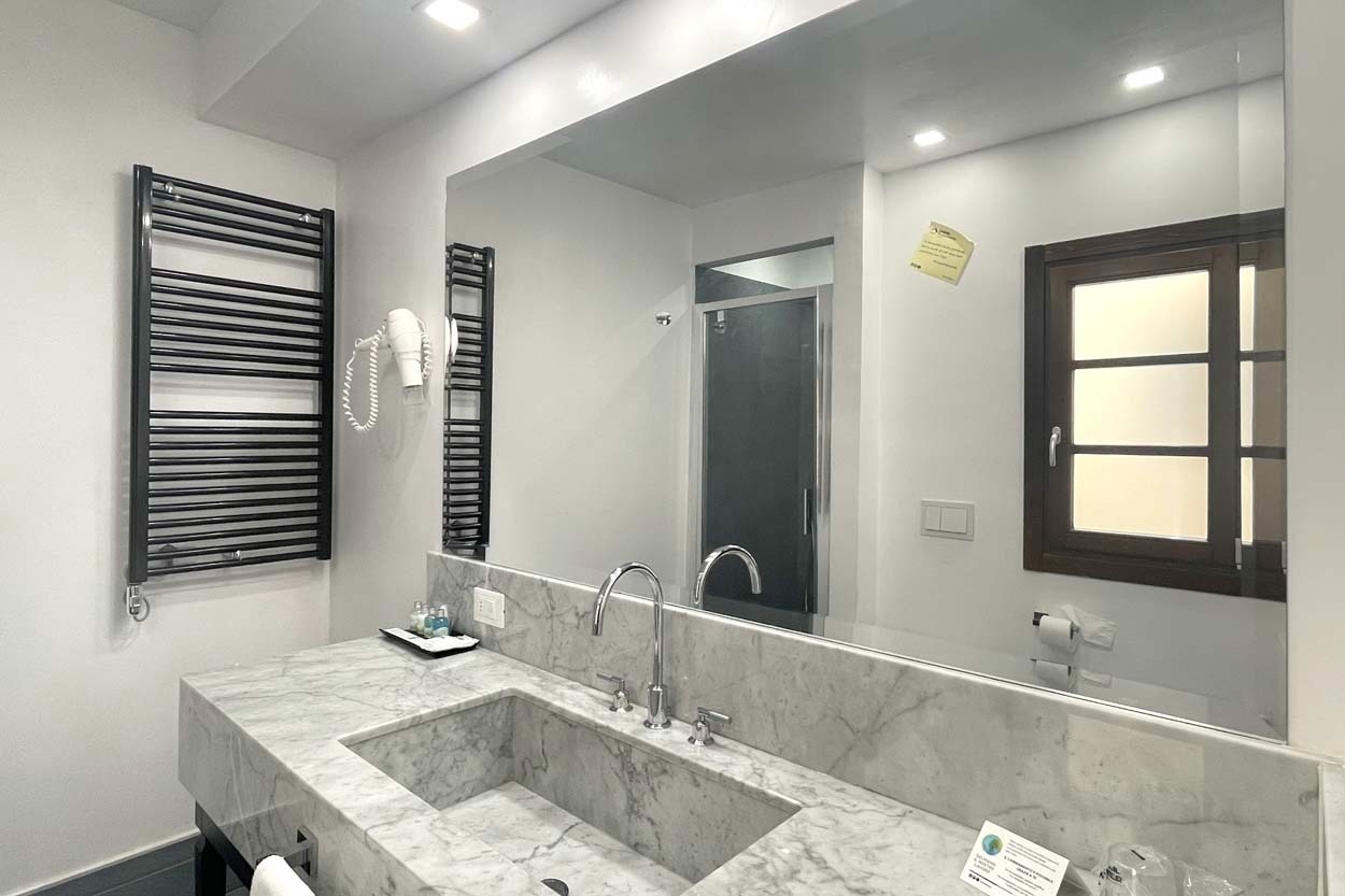 Modernes Badezimmer im Casual Rinascimento Firenze mit Marmorspüle und Heizkörper.
